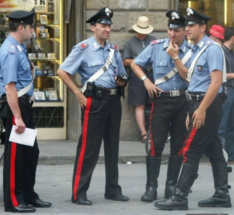 Four Italian policemen in light blue shirts